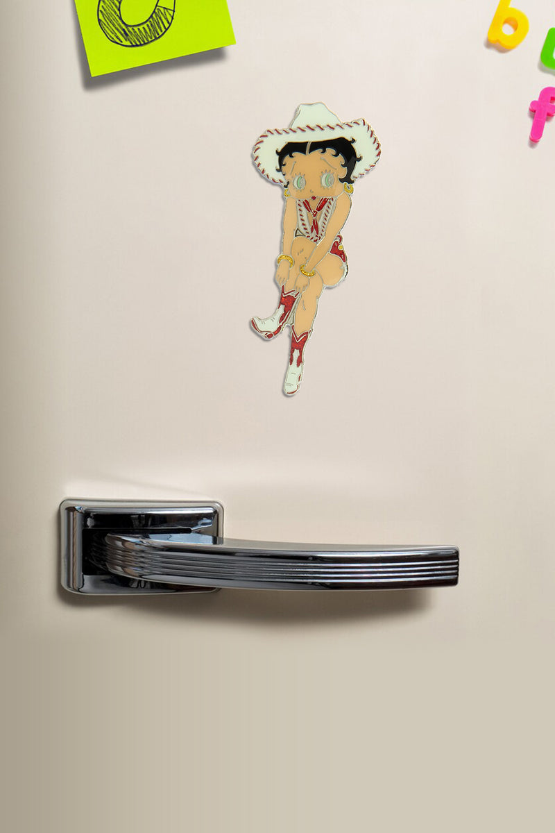 Betty Boop Fridge Magnet Cowgirl Betty is in a pink dress and posing with a guitar.This fridge magnet sticks easily to the fridge or any other magnetic surface where magnets can stick to. Betty Boop Cowgirl fridge magnet has a fine quality craftsmanship. Exclusively Available at Reliance Gifts www.reliancegifts.co.uk